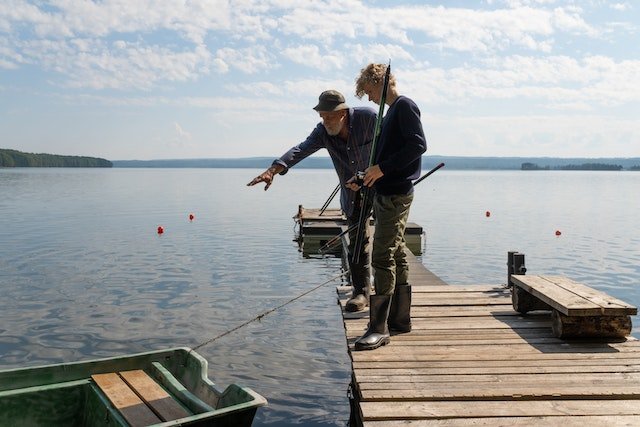 grandfather and grandson fishing in a lake